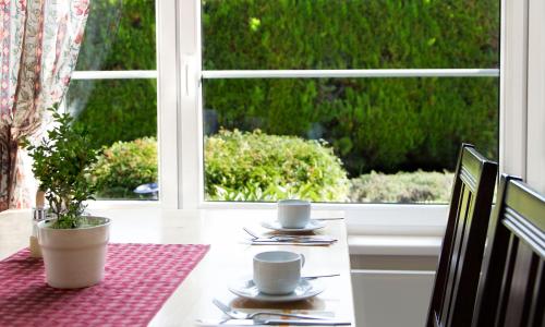 a table with two cups on a table with a window at Landhaus Pannonia in Mörbisch am See