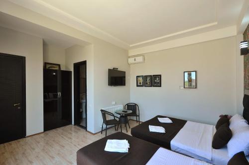 a hotel room with two beds and a table at Hotel Marsel in Tbilisi City