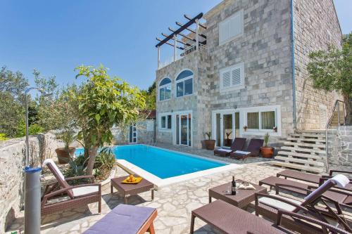 a villa with a swimming pool in front of a building at Villa Imperial View in Zaton