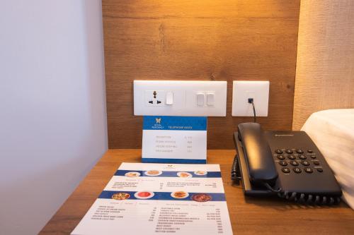 a desk with a phone and a box on it at Royal Residency in Kakkanad