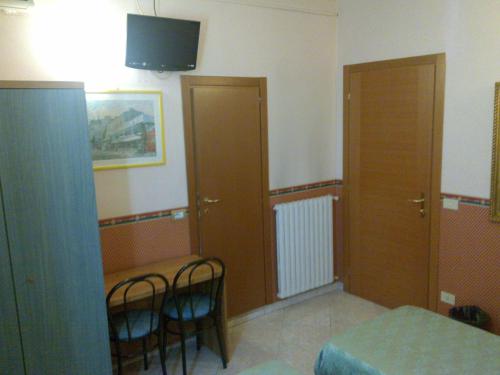 a room with two chairs and a bed and a tv at Hotel Lazzari in Rome