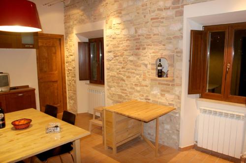 una cucina con tavolo in legno e parete in pietra di Casa Ventura ad Arcevia