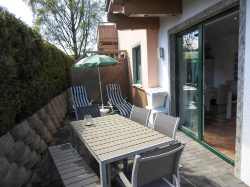 a wooden table with chairs and an umbrella on a patio at Ferienwohnung Julia in Brixen im Thale