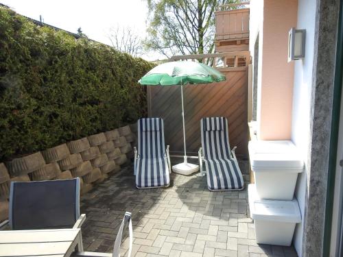 two chairs and an umbrella on a patio at Ferienwohnung Julia in Brixen im Thale