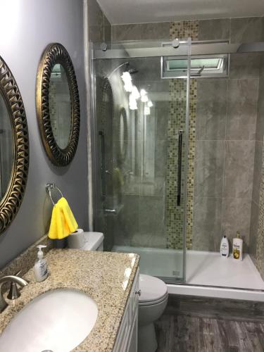a bathroom with a shower and a toilet and a sink at Lake and Bridge View Vacation Home in West Kelowna