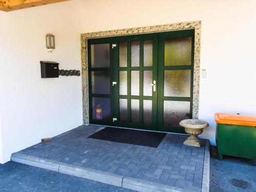 a green door with a bench in front of it at Ferienwohnung Julia in Brixen im Thale