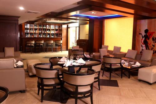 a restaurant with tables and chairs and a bar at Le Lac Sarovar Portico- Ranchi in Rānchī