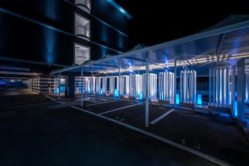 a building with blue lights in a parking lot at HOTEL Dior7 in Hamamatsu
