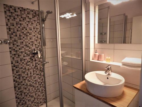 uma casa de banho com um lavatório e um chuveiro em Pension Haus Heitzig em Lippstadt