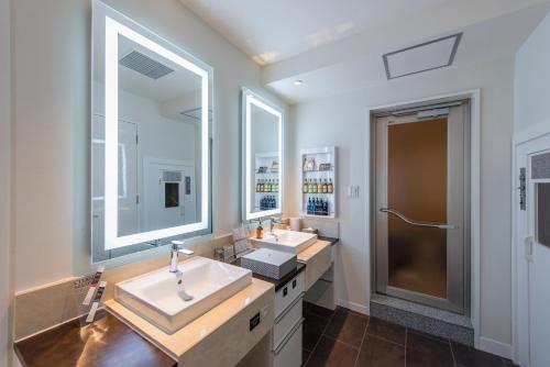 a bathroom with two sinks and two mirrors at HOTEL Dior7 in Hamamatsu