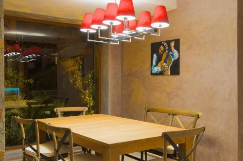 a dining room with a wooden table and red lights at Marisol Boutique Hotel in Gundogan