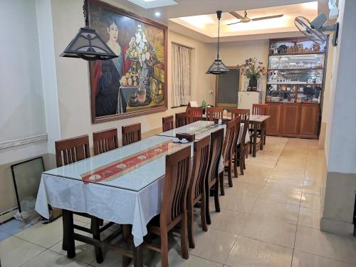 a dining room with tables and chairs and a painting at Le Thanh Hotel in Hai Phong