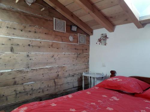 a bedroom with a wooden wall and a red bed at Ker Capcir in Bolquere Pyrenees 2000