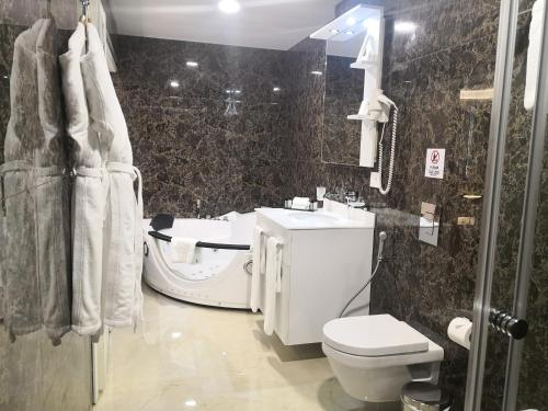 a bathroom with a white toilet and a sink at Maximus Hotel Byblos in Jbeil