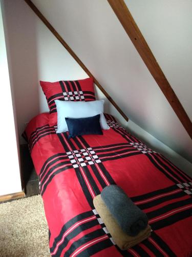a red bed with two pillows on top of it at Dolina Rosy in Ustrzyki Dolne