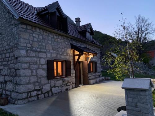 a stone house with a driveway in front of it at Lovcen Holiday Home in Cetinje