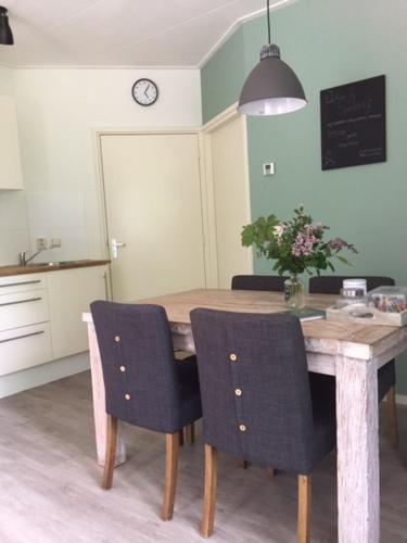 une cuisine avec une table en bois et deux chaises dans l'établissement Speldehof, à Kraggenburg