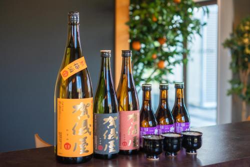 a group of bottles of wine sitting on a table at I-Link Hostel & Cafe Shimanami in Imabari