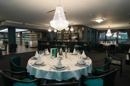 a dining room with a table and chairs and a chandelier at Grand Hotel Riga in Ruse