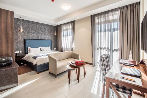 1 dormitorio con cama, sofá y mesa en Glam Hotel, en Nairobi