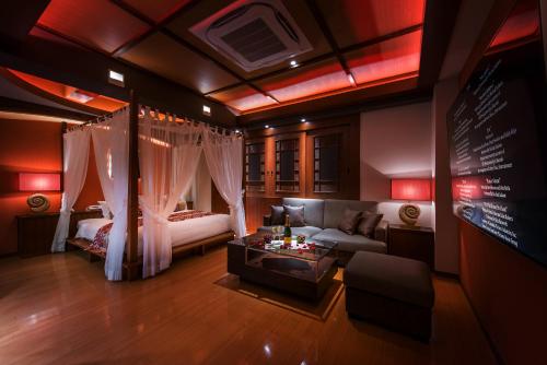 a living room with a couch and a bed at HOTEL Dior7 in Hamamatsu