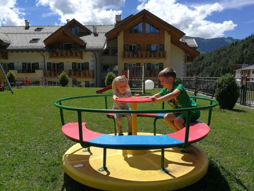 a boy and a girl playing on a trampoline at Rio Stava Family Resort & Spa in Tesero