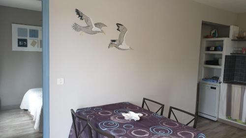 een kamer met een tafel met vogels aan de muur bij Gîte A l'ombre du clocher in Calenzana