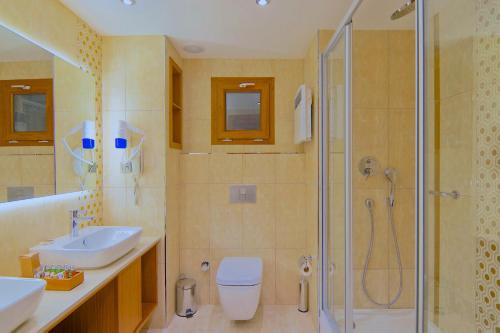 a bathroom with a shower and a toilet and a sink at Marisol Boutique Hotel in Gundogan