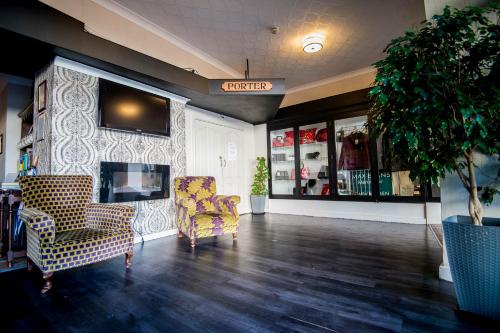 a lobby with two chairs and a tv on a wall at Ivy Bush Royal Hotel by Compass Hospitality in Carmarthen