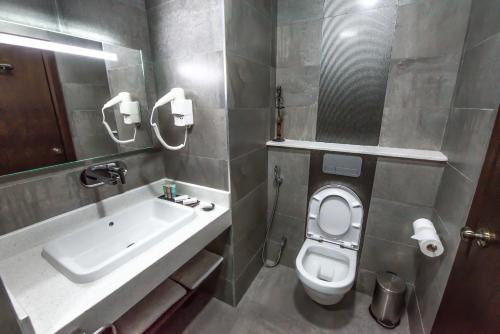 a bathroom with a toilet and a sink at Glam Hotel Nairobi - Near Westgate Mall, Westlands in Nairobi