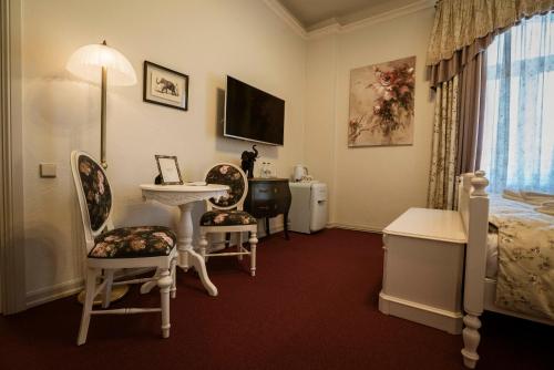um quarto com uma cama, um lavatório e cadeiras em Roze Villa em Liepāja
