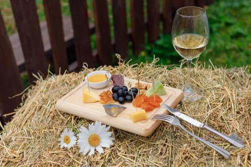 a cutting board with food and a glass of wine at Voevodyno Resort in Tur'ya Pasika