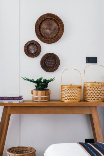 a wooden table with baskets on the wall at HOMM Boutique Hotel in Chiang Mai