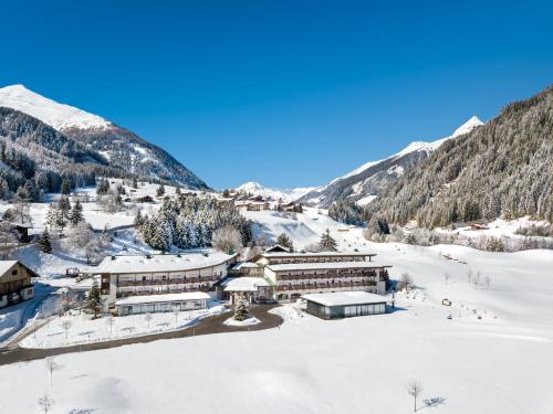ośrodek wypoczynkowy w górach w śniegu w obiekcie Defereggental Hotel & Resort w mieście Sankt Veit in Defereggen