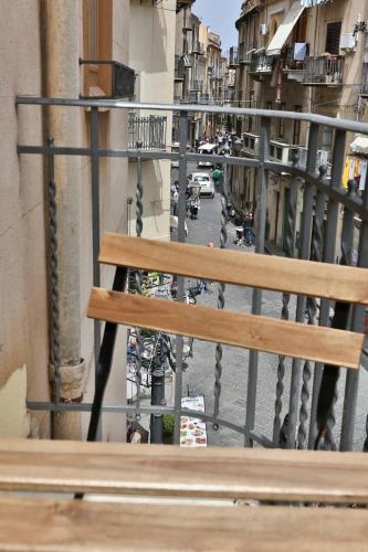 a wooden bench sitting on top of a balcony at Garibaldi B&B in Cefalù