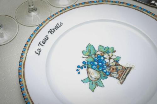 a plate with a picture of grapes on it at Logis Hôtel et Restaurant La Tour Brette in Pontorson