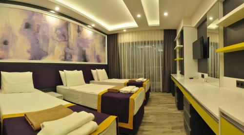 a hotel room with two beds and a tv at Campus Hill Hotel in Alanya