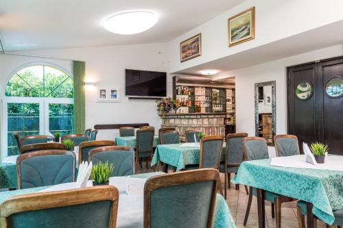 uma sala de conferências com mesas e cadeiras e uma televisão em Bed & Breakfast Villa Terezija em Baska