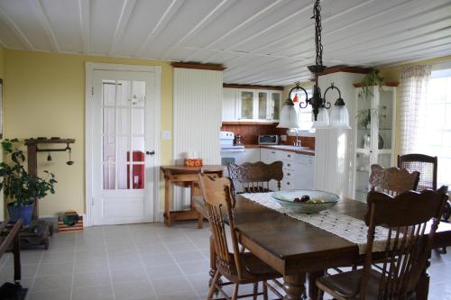 una cucina con tavolo e sedie in legno e una cucina con tavolo da pranzo di Gîte Au Blanc Marronnier a Racine
