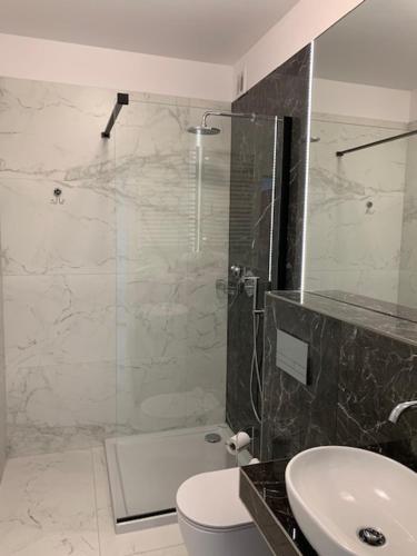 a bathroom with a shower and a toilet and a sink at Apartament Sloneczny in Kołobrzeg