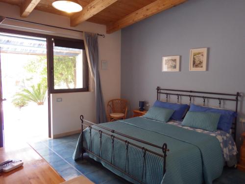 1 dormitorio con cama y ventana grande en B&B Masseria Liberatore, en Mattinata