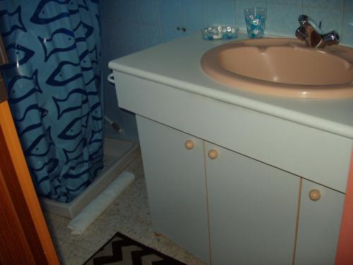 une salle de bain avec un lavabo et une douche dans l'établissement maison de vacance, à Pomérols