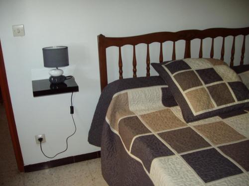 une chambre avec un lit avec une lampe sur une table dans l'établissement maison de vacance, à Pomérols