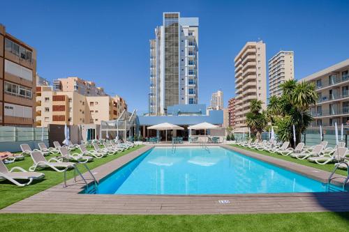 a swimming pool with lounge chairs and a building at Benidorm Centre - Adults Only in Benidorm