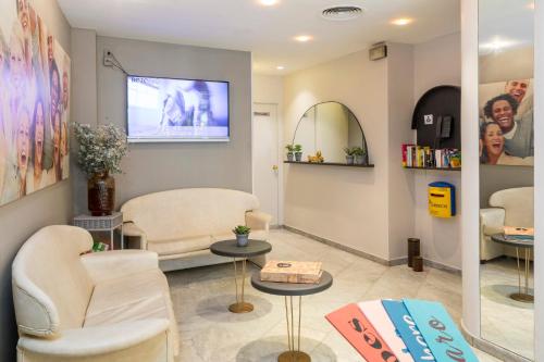 uma sala de espera com duas cadeiras e uma televisão de ecrã plano em Hotel Bulevard em Platja d'Aro