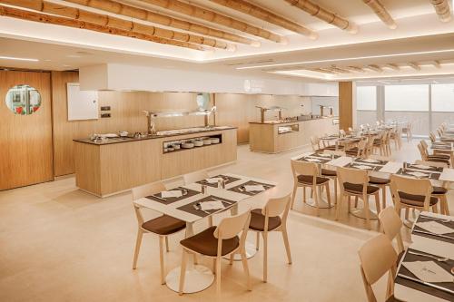 a restaurant with tables and chairs and a kitchen at Benidorm Centre - Adults Only in Benidorm