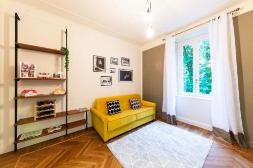 a living room with a yellow couch and a window at ReGo Holiday Apartments City Center in Bergamo