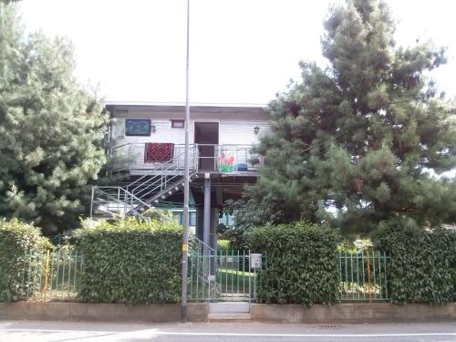 a building with a staircase in the middle of two trees at BGY Airport Guesthouse in Orio al Serio