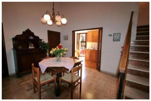 ein Esszimmer mit einem Tisch und einer Blumenvase darauf in der Unterkunft La Torre Useppi in San Gimignano