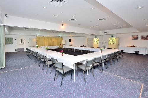 a large conference room with a long table and chairs at Manukau Hotel & Conference Centre in Auckland